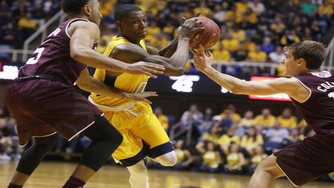 West Virginia guard Teyvon Myers (0) splits Texas A&M guard JC Hampton (5) and Texas A&M guard Chris Collins (12) as he drives to the basket during the second half Saturday in Morgantown, W.Va.