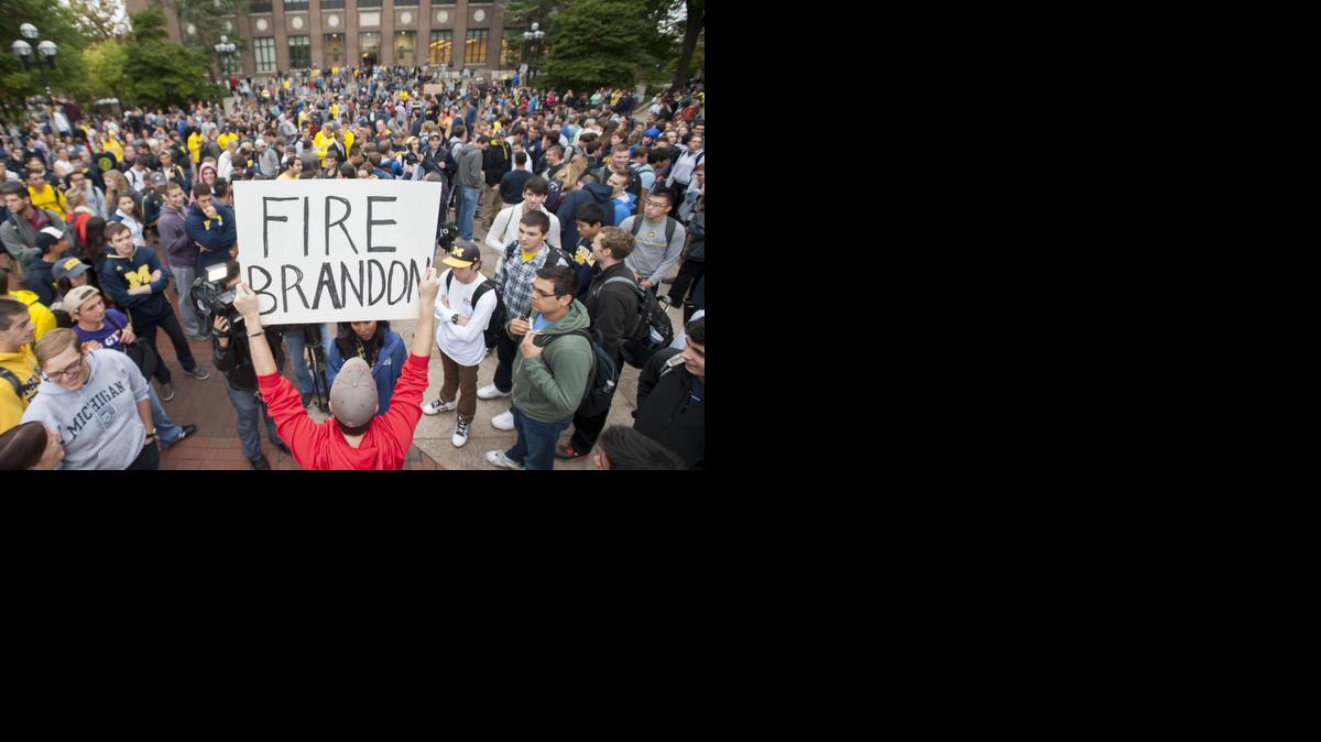 
In a Sept. 30, 2014 photo, law student Edward Mears holds a "Fire Brandon" sign during a protest on the campus of the University of Michigan 
