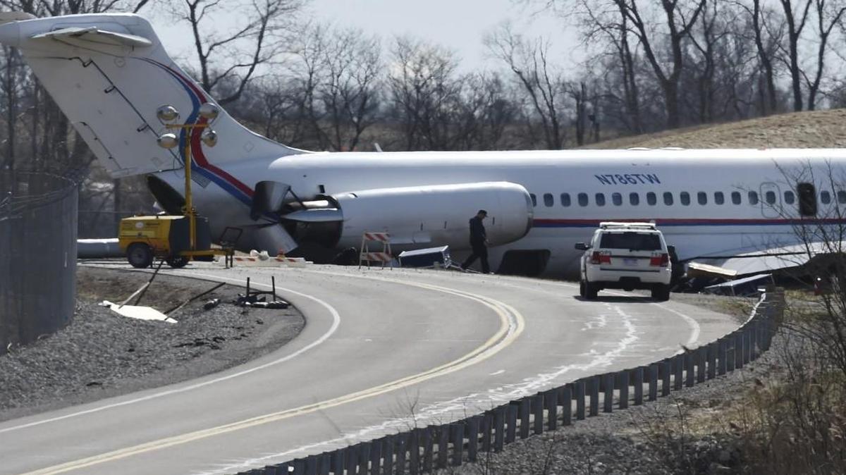 In this March 9, 2017, photo, investigators continue to inspect a plane, which was carrying the Michigan men’s basketball team, and slid off a runway during an aborted takeoff causing extensive damage to the aircraft and forcing passengers to exit through emergency doors onto wings and slides at Willow Run Airport, in Ypsilanti, Mich.