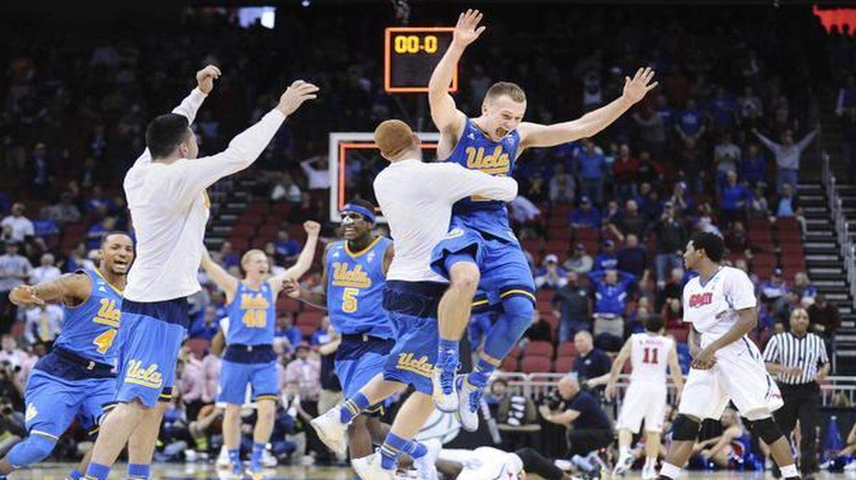 
UCLA players celebrate at the end of Thursday’s 60-59 win against Southern Methodist in the second round of the NCAA Tournament at Louisville, Ky.
