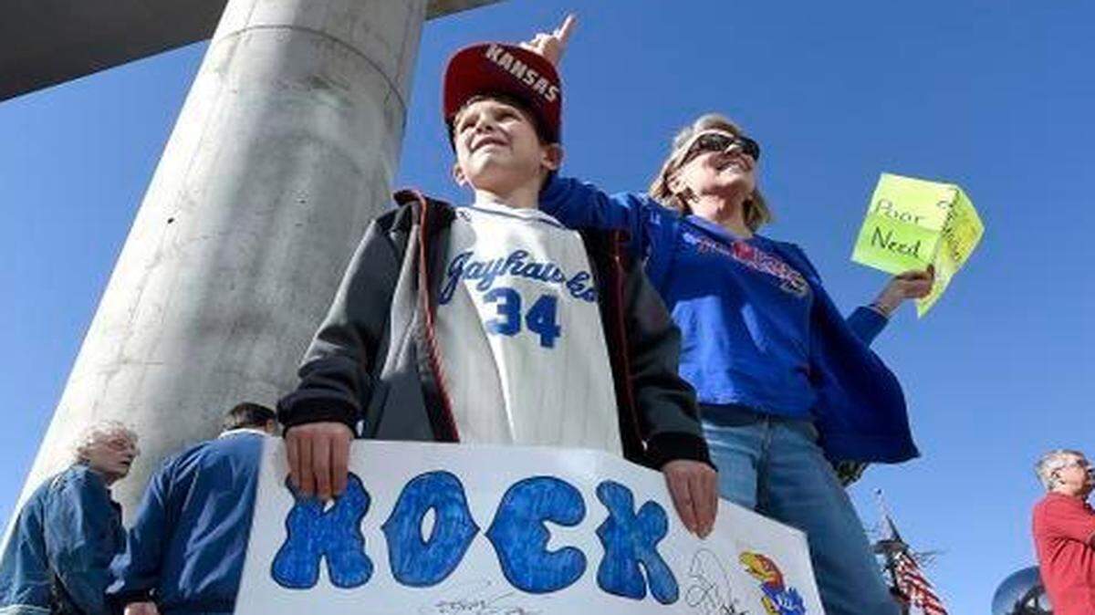 
Gerry Bukaty, from Lawrence, was looking for tickets to Sunday’s game as her grandnephew Marek Gregory, 9, from Overland Park, held tight to his sign after Wichita State advanced to play KU following Friday’s NCAA Tournament games at the CenturyLink Center in Omaha, Neb.
