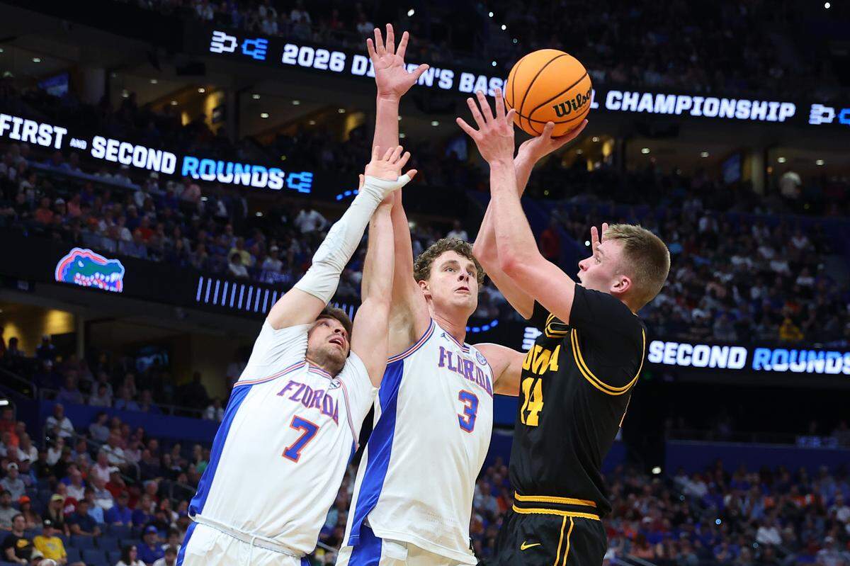TAMPA, FLORIDA - MARCH 22: Bennett Stirtz #14 of the Iowa Hawkeyes shoots the ball against Urban Klavzar #7 and Micah Handlogten #3 of the Florida Gators during the first half in the second round of the 2026 NCAA Men’s Basketball Tournament at Benchmark International Arena on March 22, 2026 in Tampa, Florida. (Photo by Mike Carlson/Getty Images)