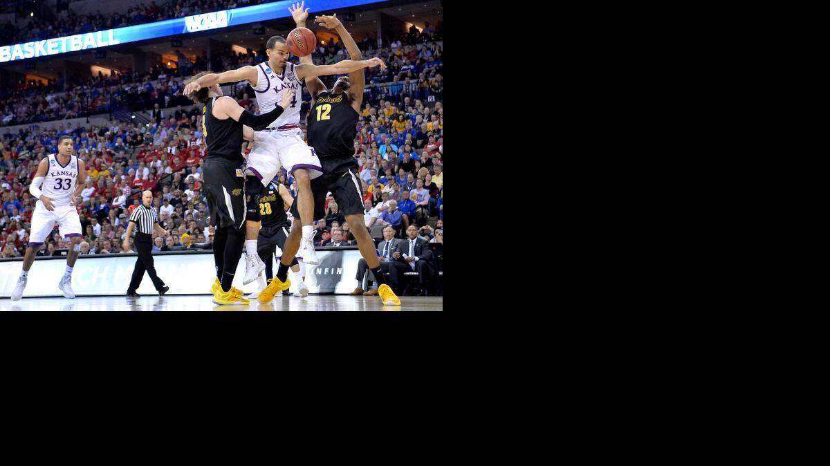
KU's Perry Ellis is stripped of the ball by WSU's Evan Wessel (left) and Darius Carter during the second half of Sunday's NCAA Tounament game in Omaha. WSU beat KU, 78-65.
