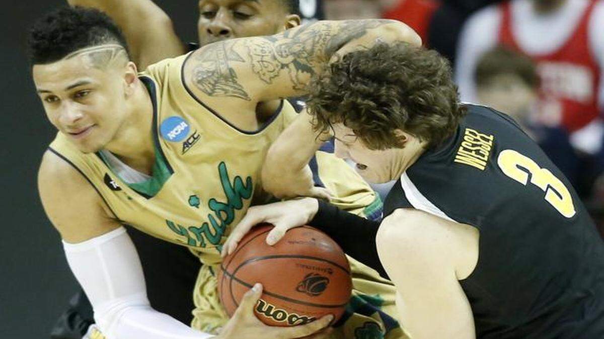 
Notre Dame forward Zach Auguste and Wichita State guard Evan Wessel fight for the ball during the first half of their game against in the Midwest Regional semifinal of the NCAA Tournament at Quicken Loans Arena in Cleveland.
