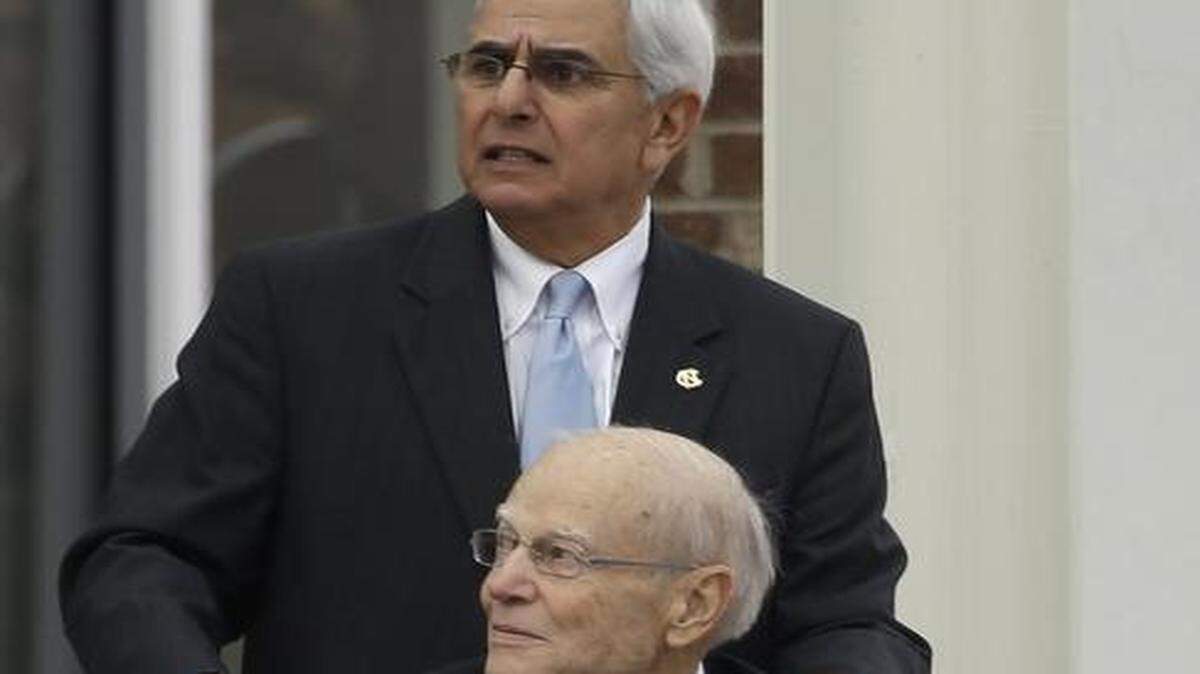 
Former North Carolina dthletic director Dick Baddour, rear, assisted former North Carolina basketball coach Bill Guthridge following funeral services for former North Carolina basketball coach Dean Smith.

