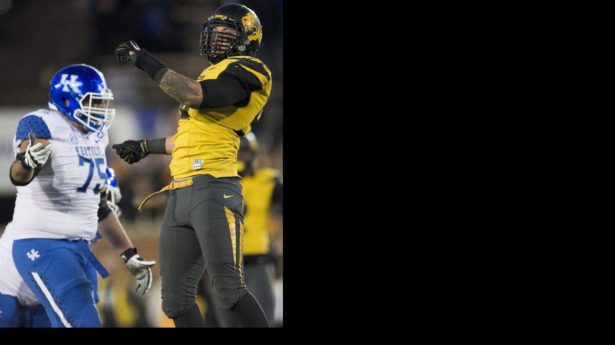 
Missouri Tigers defensive lineman Shane Ray (56) celebrates his record setting sack of Kentucky Wildcats quarterback Patrick Towles (14) as he lays on the turf in the fourth quarter during Saturday's Univeristy of Missouri and University of Kentucky SEC football game at Faurot Field on Nov. 1, 2014 in Columbia, Mo. Missouri beat Kentucky 20-10. Ray set a University of Missouri record for sacks in a single season with 12 during the game. 
