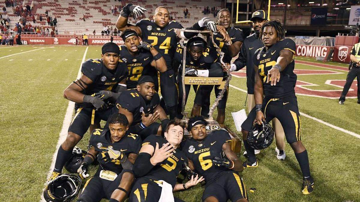 Missouri players posed with the Battle Line Trophy after the Tigers beat Arkansas 48-45 on Friday in Fayetteville, Ark.