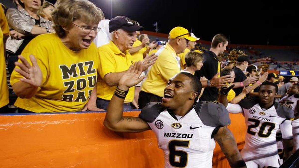 
Missouri running backs Marcus Murphy (6) and Trevon Walters (20) celebrated with fans after the Tigers defeated Florida 42-13 on Saturday night in Gainesville, Fla. Murphy scored three times in the game with a kickoff return for a touchdown, a rushing touchdown and a punt return for a touchdown.
