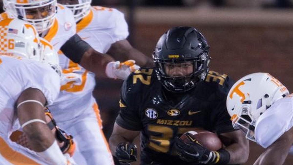 Missouri senior running back Russell Hansbrough was surrounded by Todd Kelly Jr. (6), Malik Foreman (right) and other Tennessee defenders.