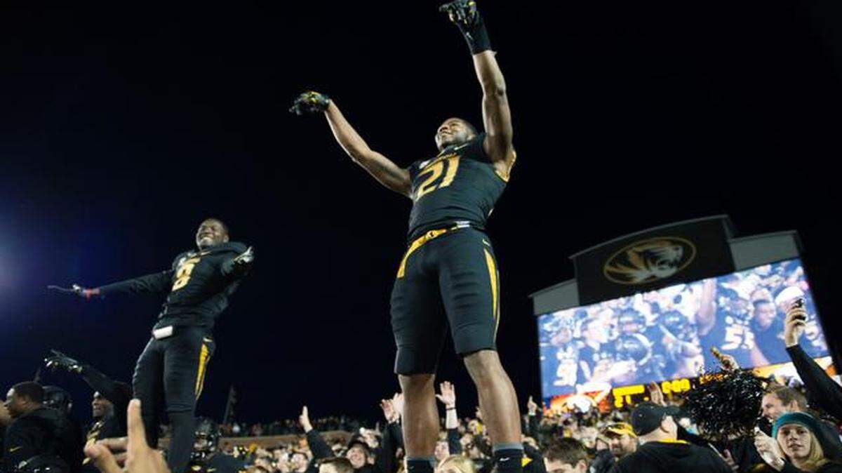 
Missouri wide receivers Darius White (8) and Bud Sasser (21) climbed onto the Faurot Field wall Saturday to celebrate with students and fans after the Tigers rallied to beat Arkansas 21-14. Missouri won its second consecutive SEC East title and advances to next Saturday’s SEC Championship Game in Atlanta.
