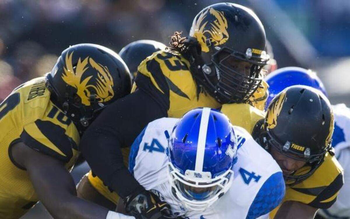 
Missouri linebacker Kentrell Brothers (10), defensive lineman Markus Golden (33) and Braylon Webb (9) combined to tackle Kentucky running back Mikel Horton (4) for a loss in the second quarter Saturday in Columbia.
