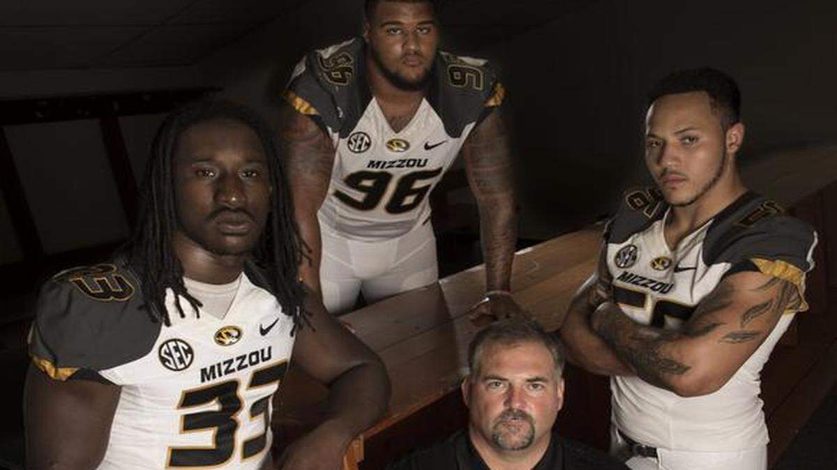
Craig Kuligowski (bottom), defensive line coach, is surrounded by Markus Golden (left), Lucas Vincent, and Shane Ray during photo day for the football team at the University of Missouri.
