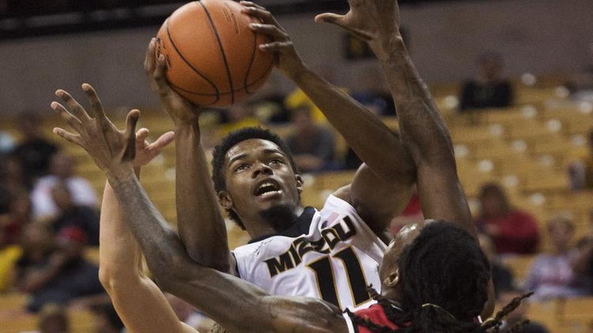 Mizzou’s K.J. Walton (center) took a shot between Central Missouri’s Marquiez Lawrence (right) and Kyle Wolf during the first half of Friday night’s exhibition game in Columbia.