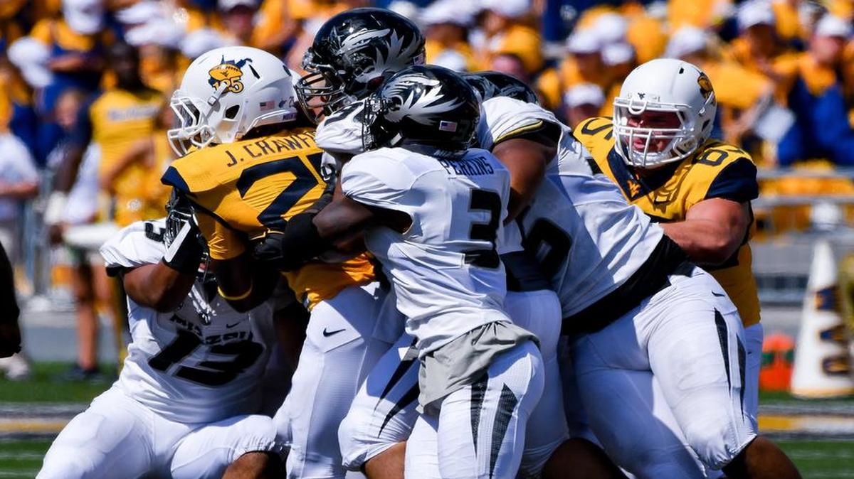 West Virginia’s Justin Crawford (25) pushed a pile of Missouri defenders for a first down during the second half Saturday.