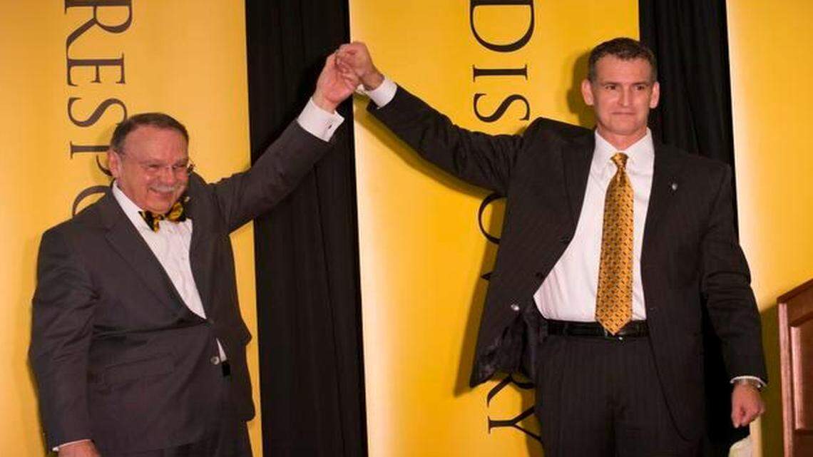 
The University of Missouri chancellor R. Bowin Loftin, left, raises the hand of the Mack Rhoades, right, after Rhodes was introduced as the university's new athletic director during a news conference, Tuesday, March 10, 2015, on the University of Missouri campus in Columbia, Mo. (AP Photo/L.G. Patterson)
