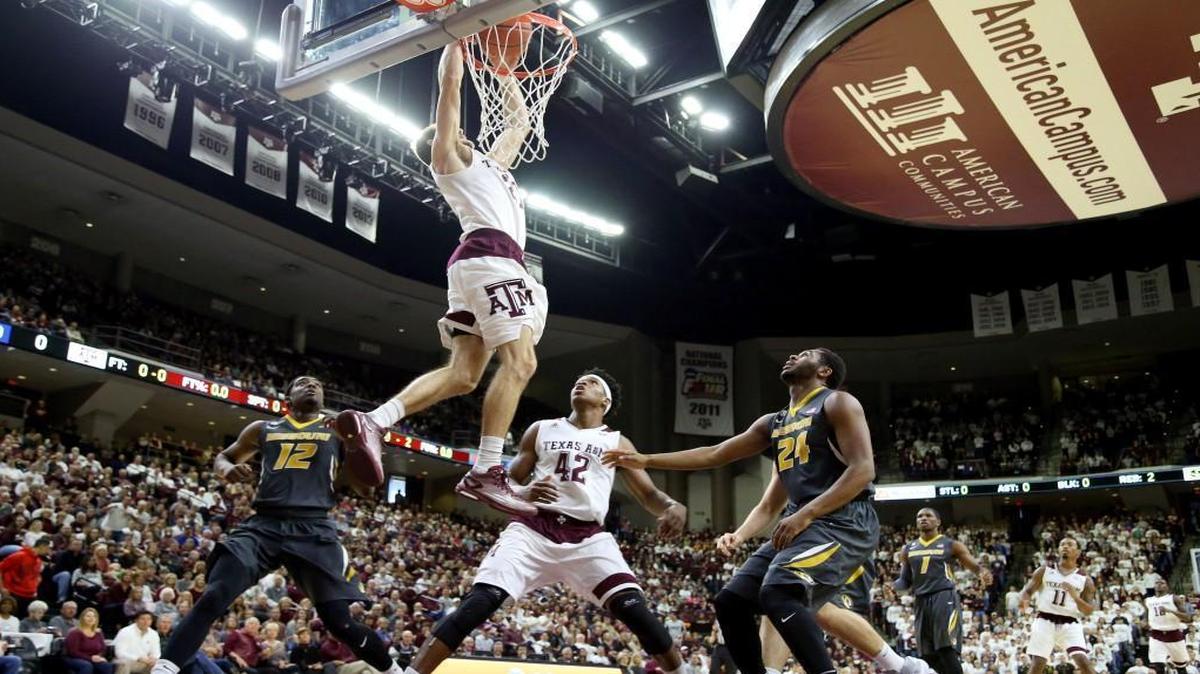 Texas A&M’s Alex Caruso (21) dunked the ball as teammate Tavario Miller (42), and Missouri’s Namon Wright (12) and Kevin Puryear (24) reacted in the first half as the No. 10 Aggies played the Tigers on Saturday in College Station, Texas.