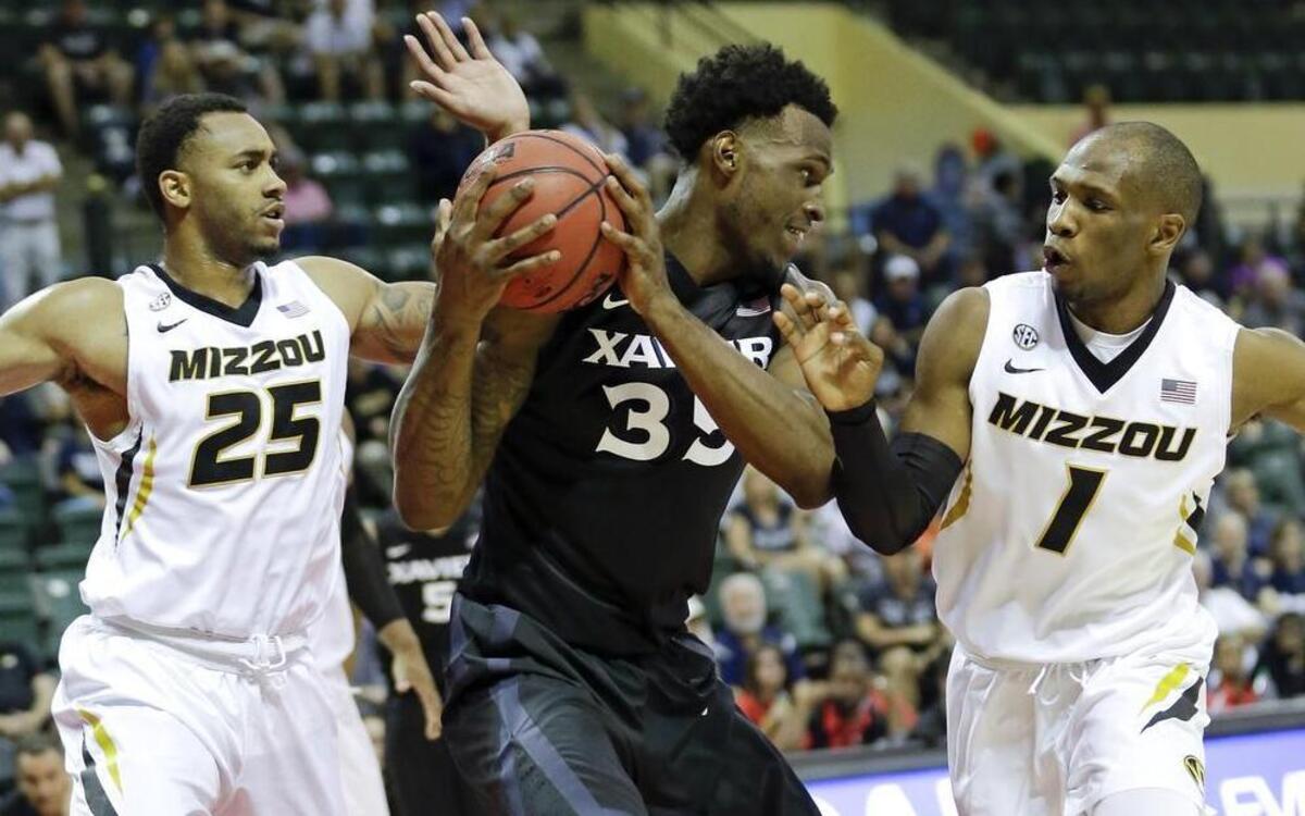 Xavier’s RaShid Gaston (center) looked to pass the ball after he was caught between Missouri’s Russell Woods (left) and Terrence Phillips.
