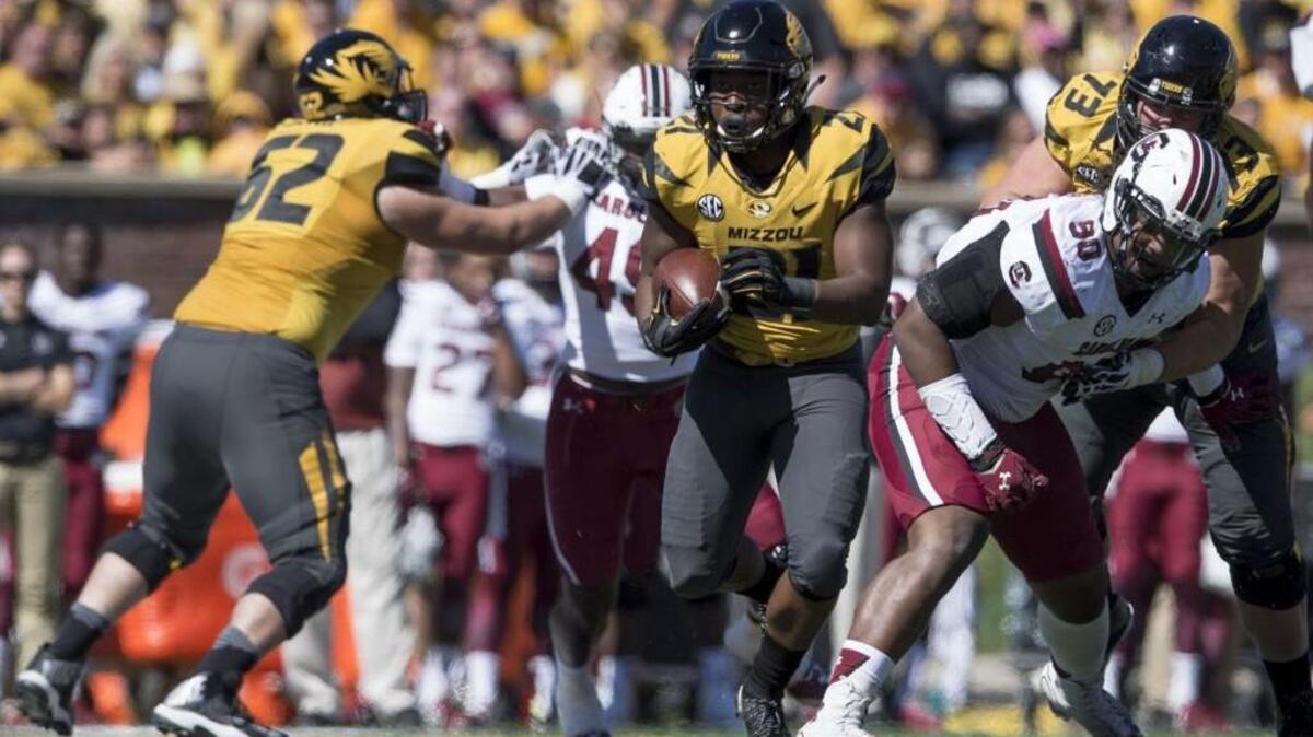 
Missouri Tigers running back Ish Witter found a hole between South Carolina’s Boosie Whitlow (left) and Taylor Stallworth during Saturday’s game.
