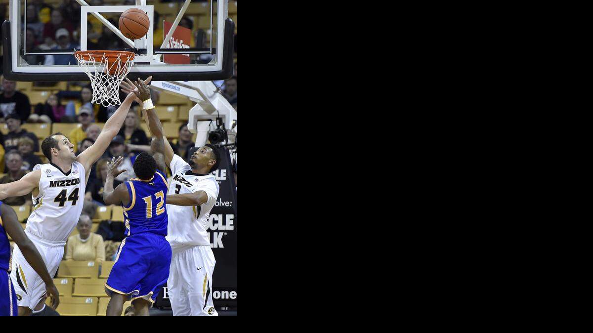 
UMKC's Martez Harrison put 26 points on Mizzou Friday night. He drove between MU’s Ryan Rosburg (left) and Johnathan Williams for a shot during the second half of Friday night's game at Mizzou Arena. UMKC won, 69-61.
