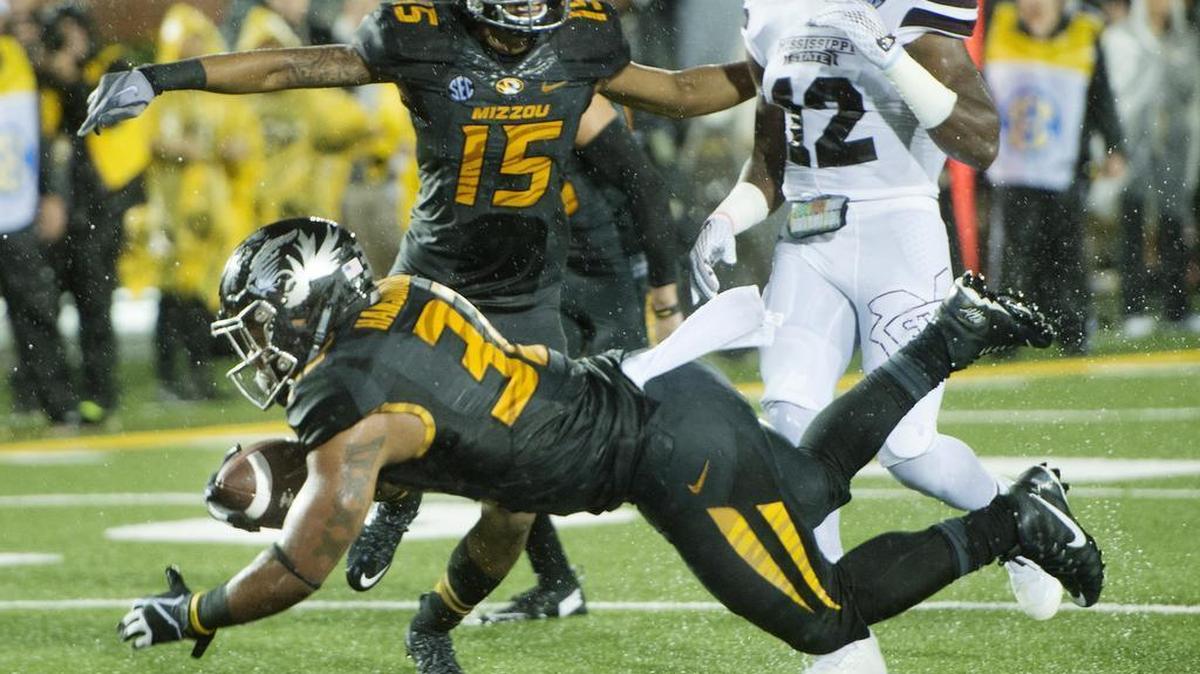 Missouri Tigers running back Russell Hansbrough goes airborne to score a touchdown against Mississippi State defenders during the second quarter of Thursday night's game at Faurot Field in Columbia, Missouri.