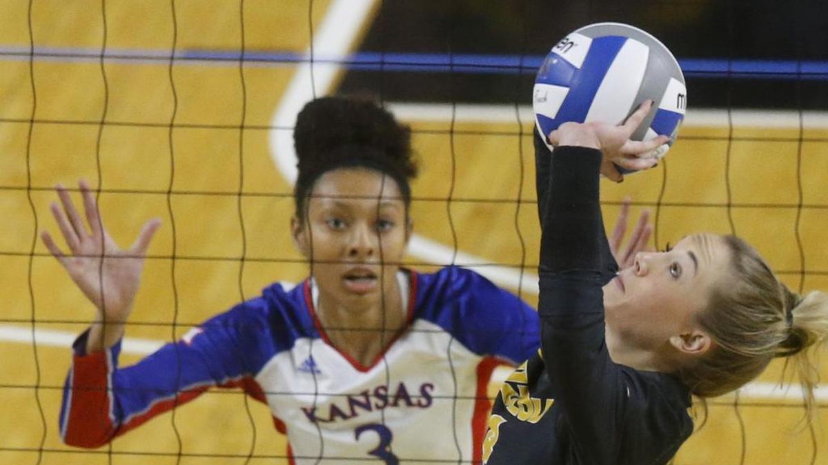 Missouri's Courtney Eckenrode (right) sets the ball as Kansas’ Kayla Cheadle watches during their match in the first round of the NCAA Tournament on Friday at Koch Arena in Wichita.
