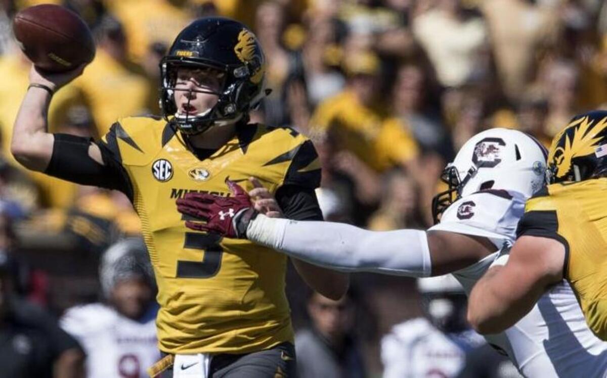 
Missouri Tigers quarterback Drew Lock threw a pass as offensive lineman Connor McGovern tried to keep a South Carolina defender away during Saturday’s game.
