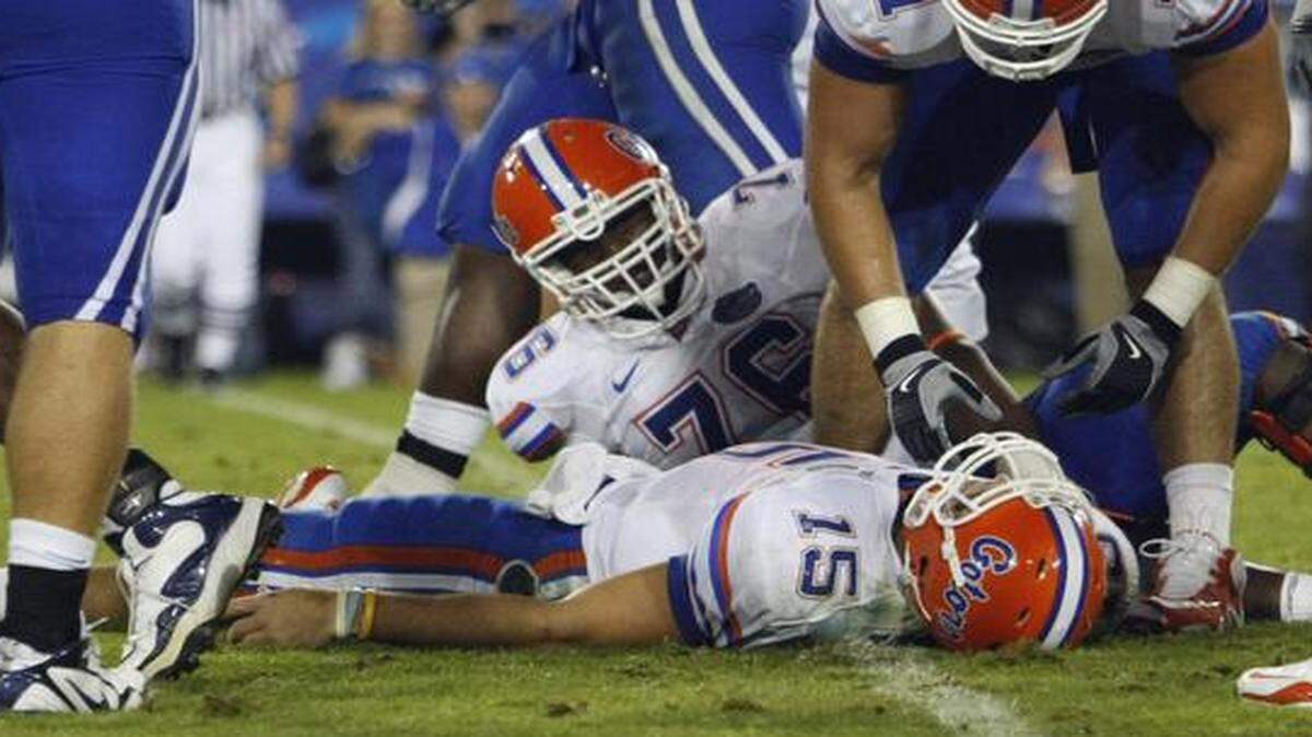 
Florida players Matt Patchan and Marcus Gilbert look on as quarterback Tim Tebow lies on the turf after being sacked during an NCAA college football game in 2009.
