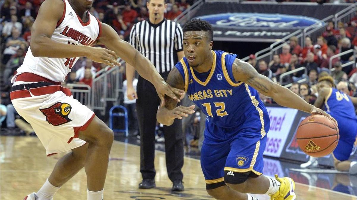 UMKC's Martez Harrison (right) attempted to drive past Louisville's Donovan Mitchell during Tuesday’s game in Louisville, Ky.