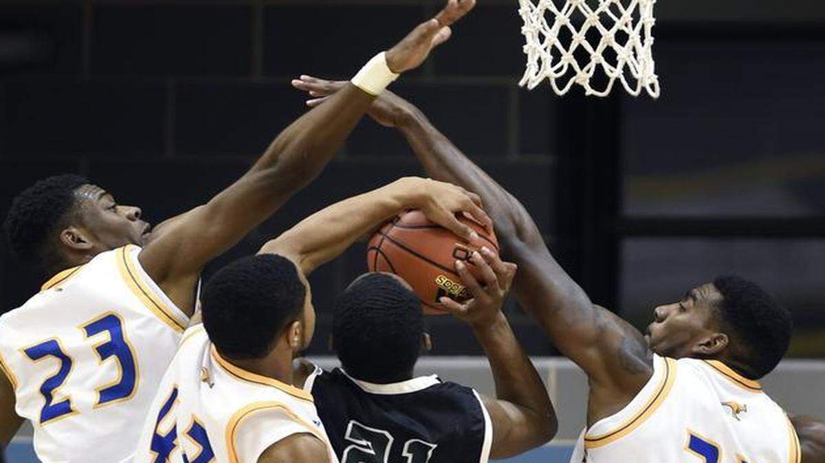 
UMKC’s Darius Austin (23) Noah Knight (42) and Thaddeus Smith teamed up to defend a shot by Missouri S&T’s Marcus Walden during a game earlier this season.
