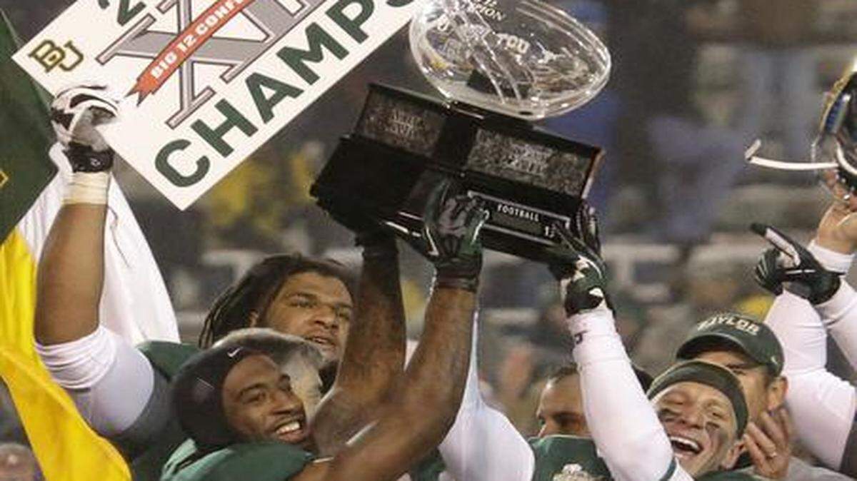 
In this Dec. 7, 2013 file photo, Baylor safety Ahmad Dixon, left, and linebacker Eddie Lackey (5) lift the Big 12 trophy after defeating Texas 30-10 in the conference championship game in Waco, Texas. The NCAA board of directors voted 16-2 on Thursday, Aug. 7, 2014, in favor of a proposal that would give the five wealthiest college football conferences the ability to make rules and pass legislation without the approval of the rest of Division I schools. 
