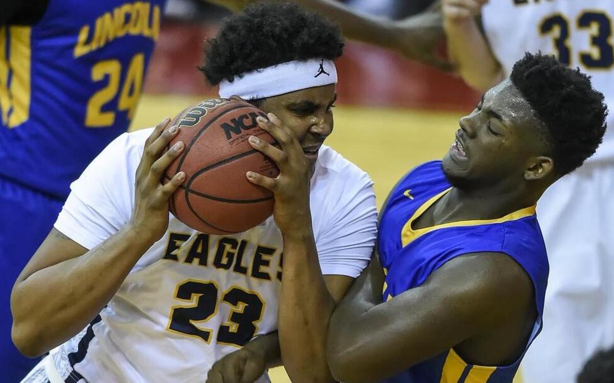 Liberty North senior Michael Hughes (left) drove to the basket against Lincoln Prep senior defender Alon Smith in a Cardinal Division semifinal game last week at the William Jewell Holiday Classic basketball tournament. Liberty North won the game, 68-46.