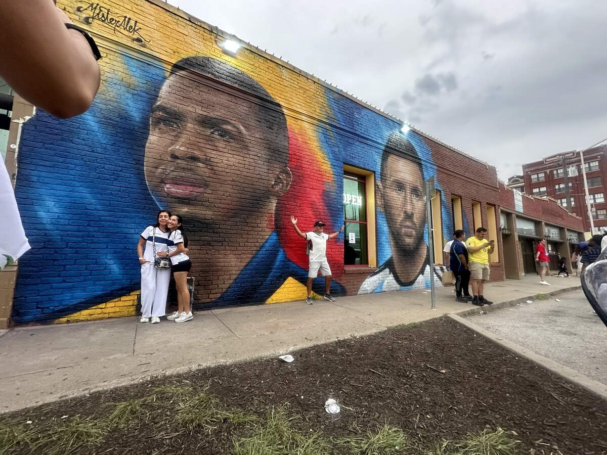 FIFA World Cup soccer fans take pictures in front of a mural in Kansas City of Ecuador defender Willian Pacho and Argentina star Lionel Messi. The mural is on the outside of Senorita Margarita, at 20th and Main Street. With efforts led by “Ecuador in KC” founder Paulina Tabares and Señorita Margarita owner Jasmine Thompson, L.A. artist MisterAlek painted the mural for the World Cup.