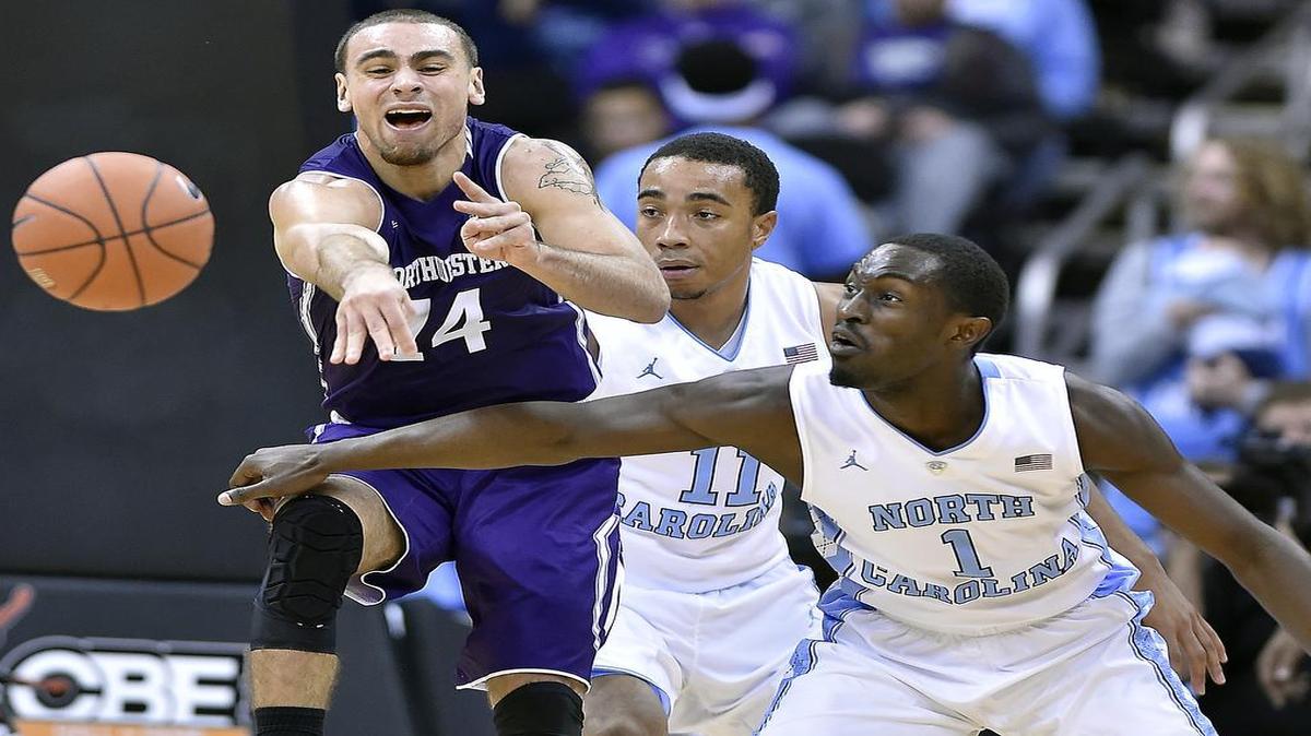 North Carolina’s Theo Pinson (far right) knocked the ball away from Northwestern’s Tre Demps during the first half of Monday night’s CBE game at the Sprint Center.