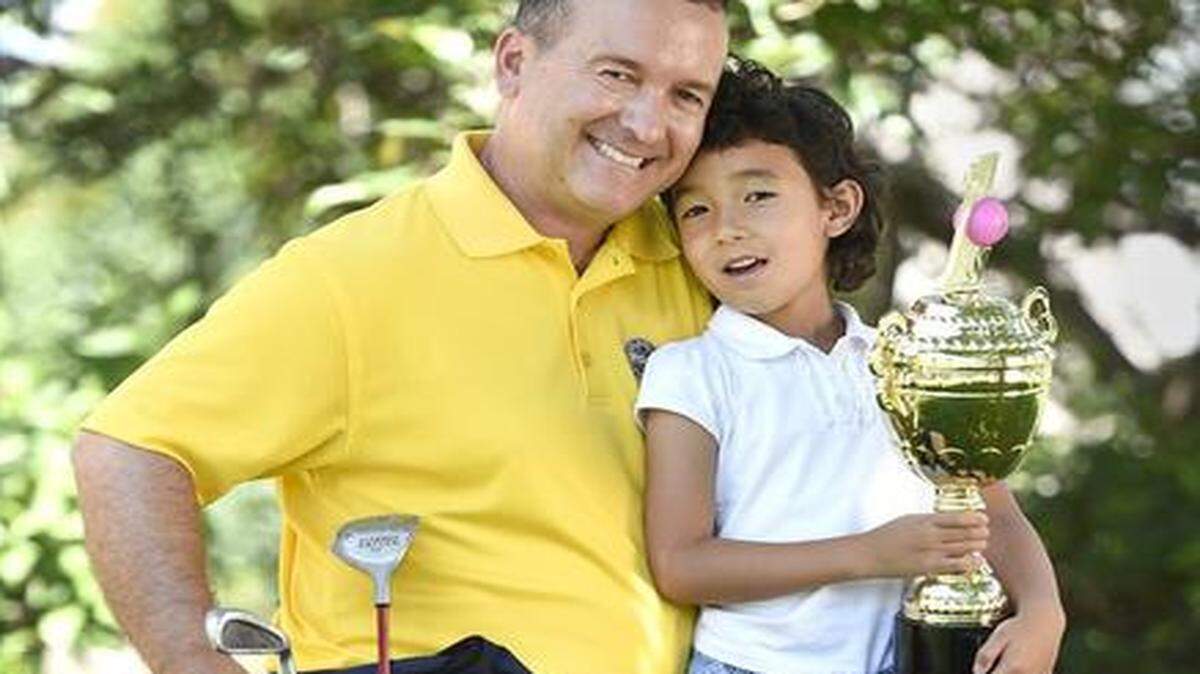 
Lynn Powell, 5, of Overland Park, earned a trophy from her dad, Jim Powell, after shooting her first hole in one.
