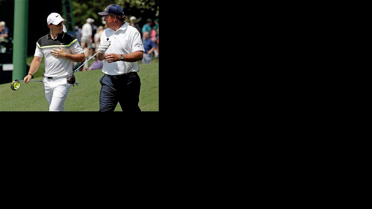 
Rory McIlroy, of Northern Ireland, walks down the ninth fairway with Phil Mickelson, right, during the first round of the Masters golf tournament Thursday, April 9, 2015, in Augusta, Ga. (AP Photo/Charlie Riedel)
