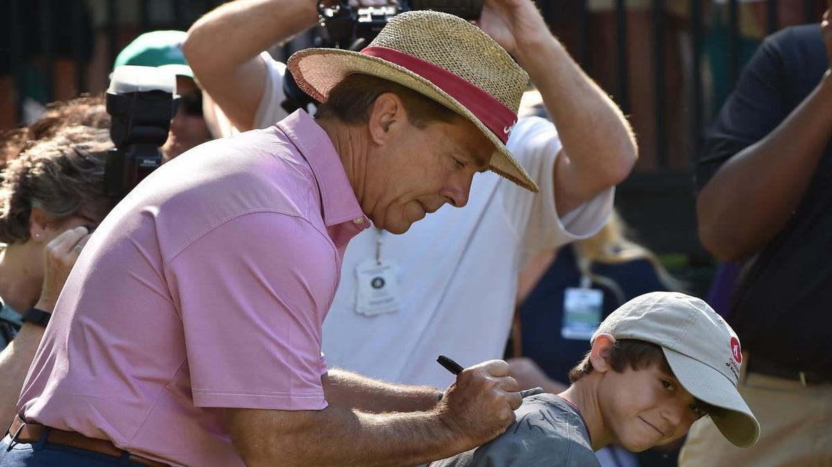 
Alabama football coach Nick Saban signed the shirt of Children's of Alabama golf tournament escort Shawn Anthony on Wednesday at Shoal Creek Country Club in Hoover, Ala.
