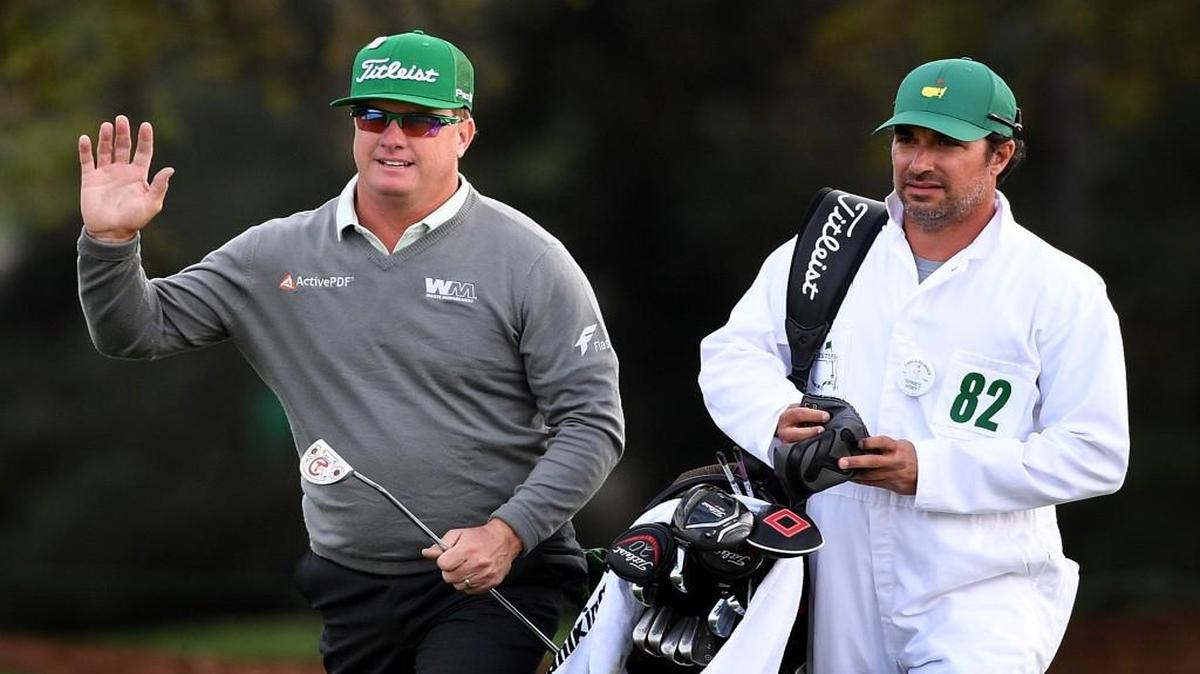 Charley Hoffman, left, acknowledges the applause of the gallery as he and his caddie, Brett Waldman, right, arrive at the 18th green during the first round of the Masters Tournament at Augusta National Golf Club on Thursday. Hoffman finished the round at 7-under par.