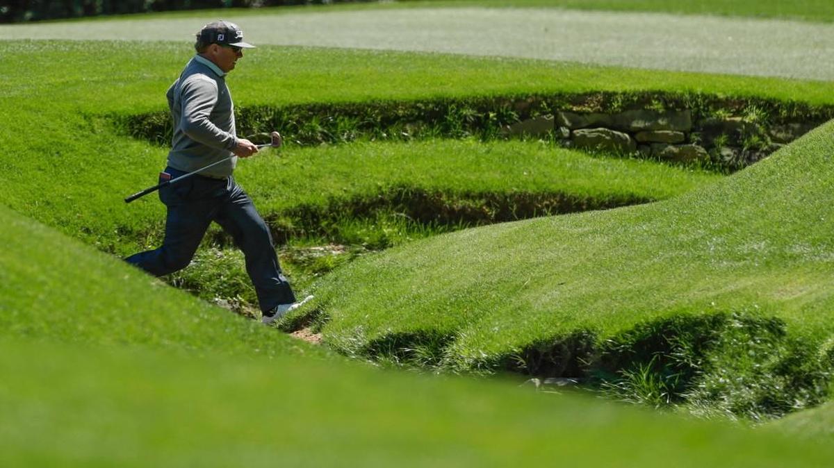 Charley Hoffman leaps over Rae’s Creek on the 13th hole during the second round of the Masters golf tournament Friday in Augusta, Ga.