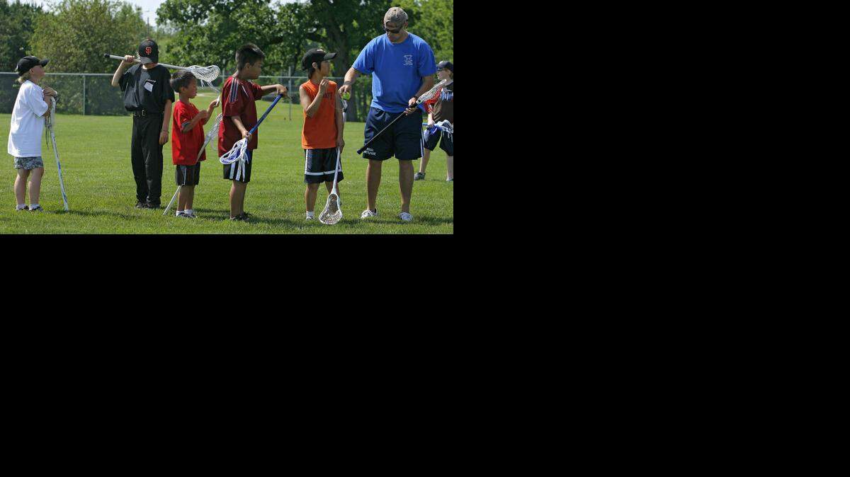 
The popularity of lacrosse has been growing in the Kansas City area over the last few years. Mark Bayhylle (right) worked with some campers at Johnson County Sertoma Fantasy Sports Camp at the Blue Valley Sports Complex in 2008.


