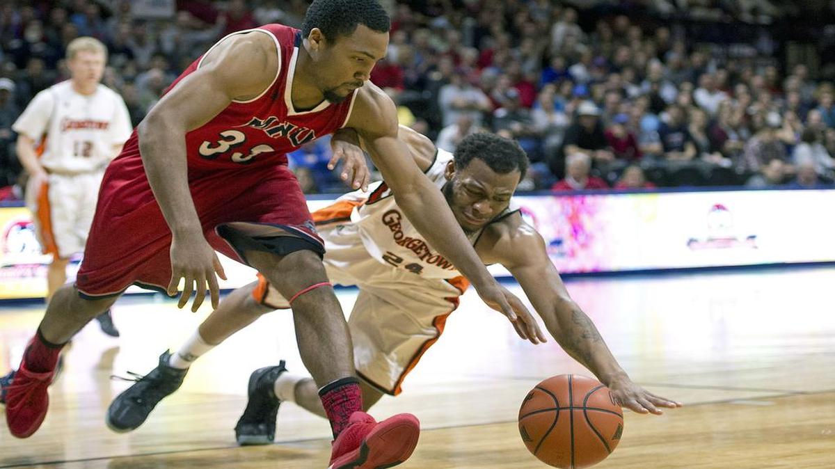 MidAmerica Nazarene’s Gabriel Jordan (No. 33) and Georgetown’s Edison Avila (No. 24) chase a loose ball during the NAIA Tournament men’s semifinal game on Monday night at Municipal Auditorium.