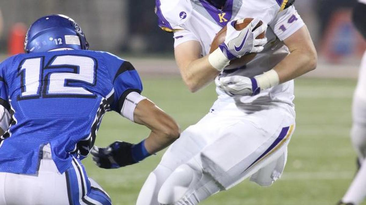Kearney tight end Cody Blodgett tries to steer clear of Harrisonville’s Nick Laughlin after making a catch. Blodgett made two catches for 41 yards.