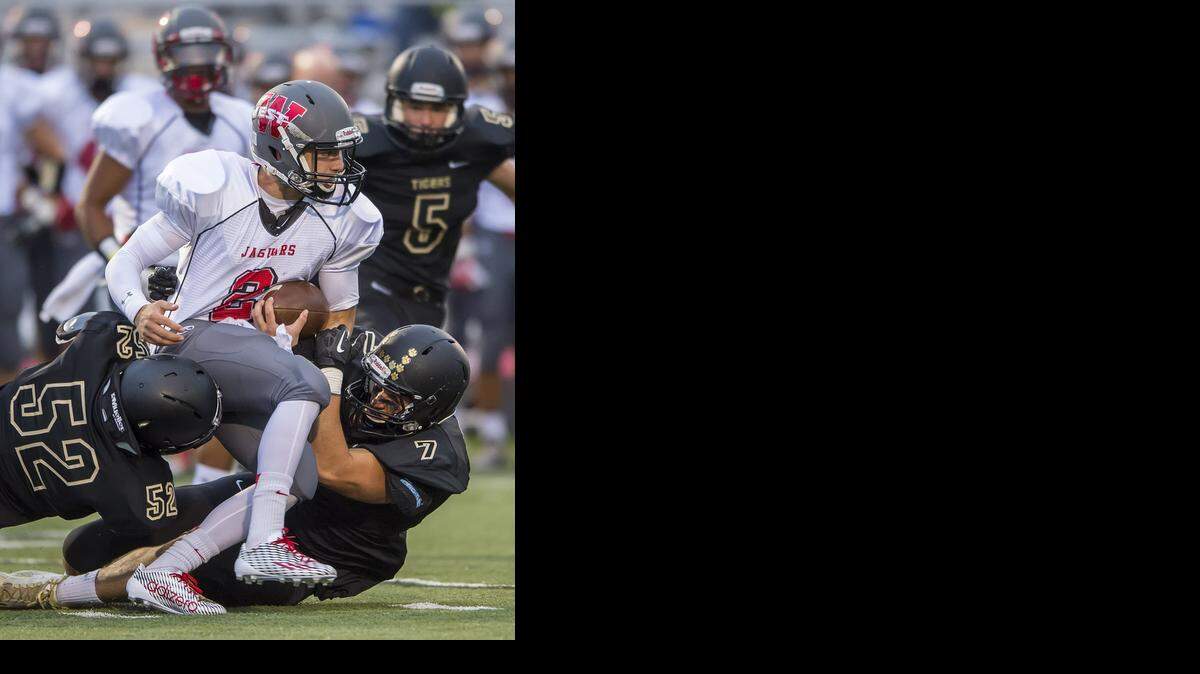
Blue Valley High School senior defensive tackle Daniel Carroll (No. 52) and senior defensive tackle Mazin Aql (No. 7) combined on a first-quarter tackle of Blue Valley West senior quarterback Zev Mallin on Friday in their game at Blue Valley High School.
