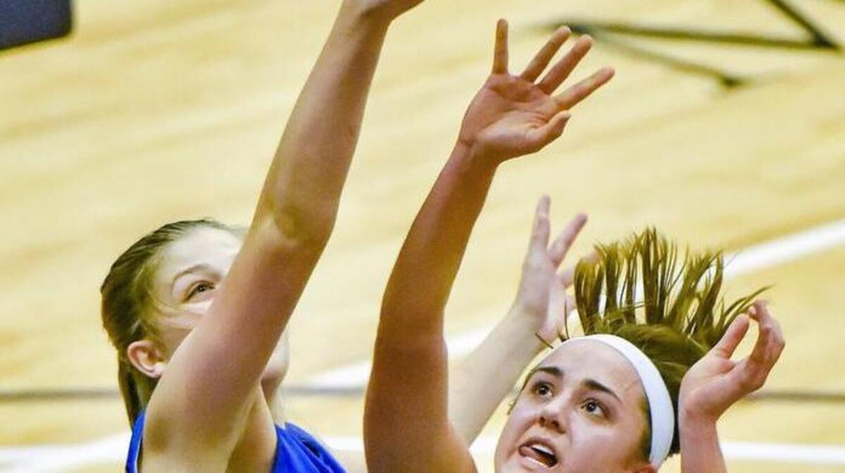 St. Pius X guard Natalie Denzer (right) aims for the basket while Leavenworth’s Abby Mack tries to knock the ball away. St. Pius X lsot to Leavenworth 41-36 Friday in the opening game of the Hy-Vee Shootout at Avila.