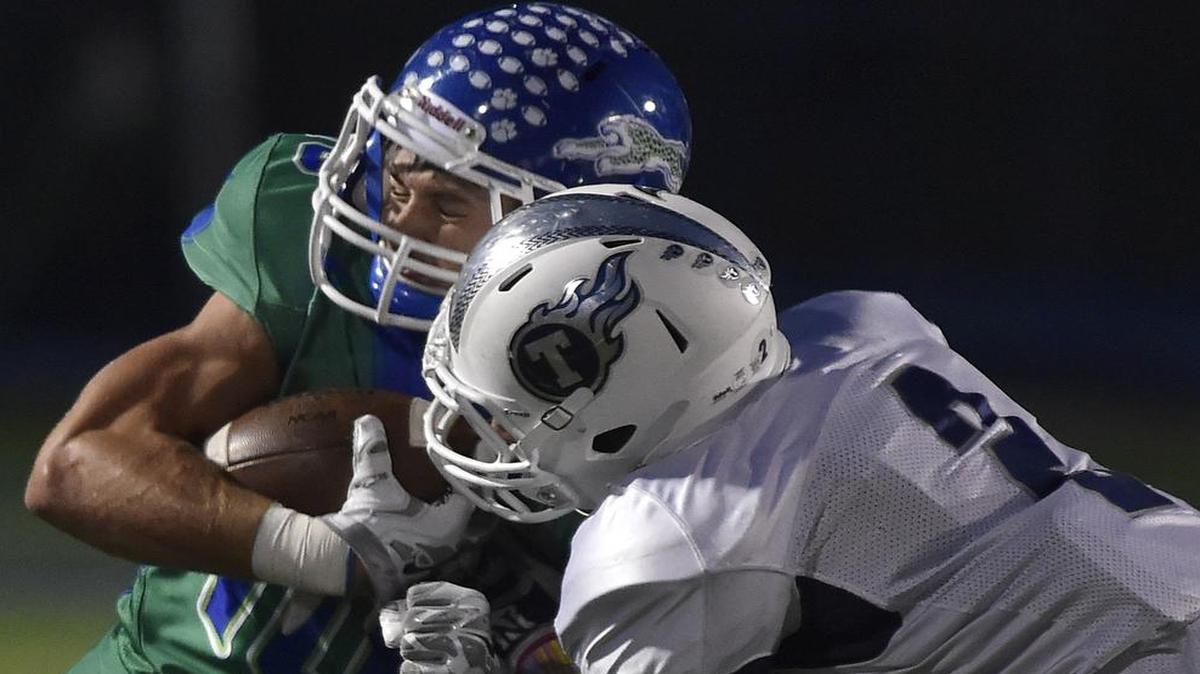 
Blue Springs South’s Justin Belcher (left) was hit by a Lee’s Summit West defender during first-half action of their game on Friday night. Blue Springs South edged the Titans, 27-21.
