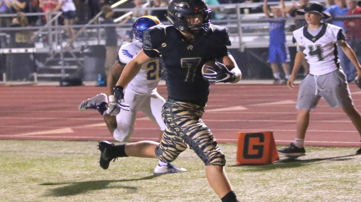 Lee’s Summit running back Preston Whitworth crosses the goal line to complete a 15-yard touchdown in the third quarter against Olathe South Friday night. Whitworth rushed for 207 yards and threw a touchdown pass in the Tigers’ 28-15 victory at Bud Hertzog Stadium.