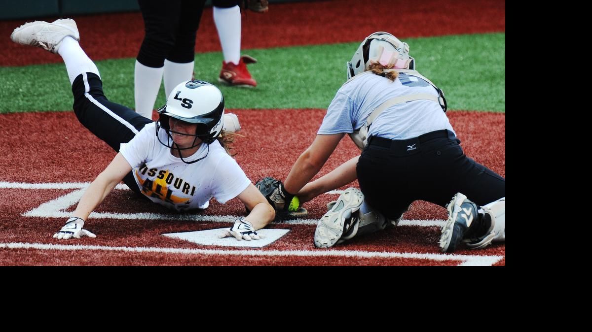 
Missouri All-Star Bailey Baird of Lee’s Summit (left) slides across home plate as Kansas All-Star catcher Lacie Myers of Mill Valley attempts to apply the tag on Monday during the first game of the MO-KAN All-Star Softball Series at the Shawnee Mission School District Softball Complex.
