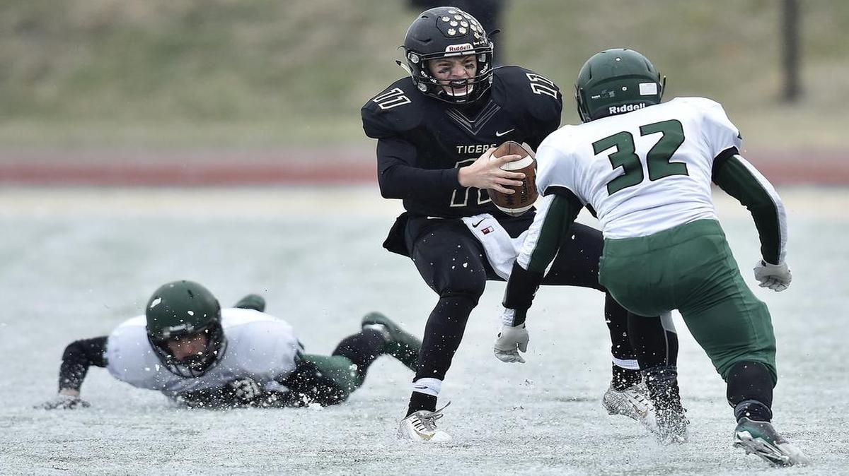 Blue Valley quarterback Colton McCumber looked for an opening among Derby defenders during second-quarter action of the Kansas Class 6A football state title game. Derby defeated Blue Valley, 27-14.
