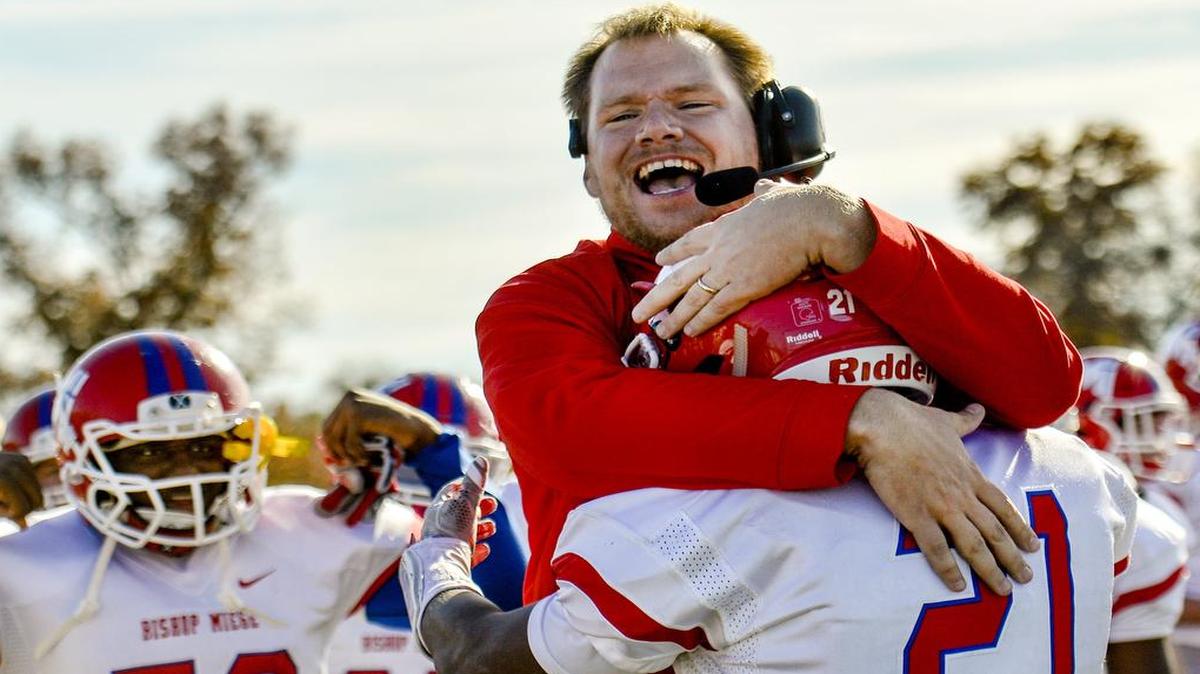 Bishop Miege coach Jon Holmes hugged Cameron Clark (21) after Clark scored a touchdown last month during the second quarter of the KSHSAA class 4A-DI state championship football game against Buhler at Hummer Sports Park in Topeka. Bishop Miege won the championship 53-21.