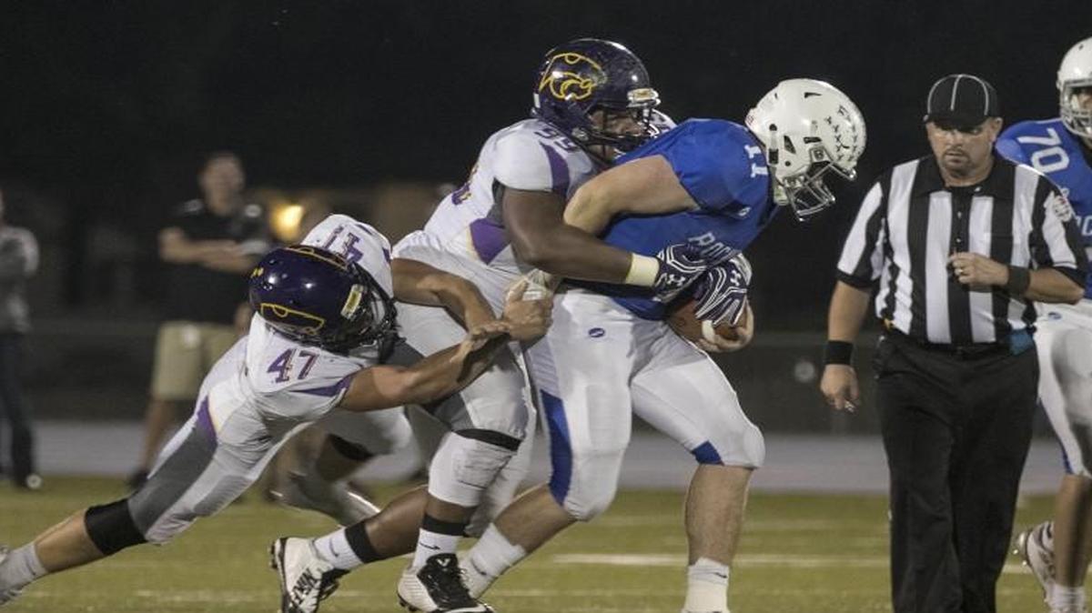The Blue Springs defense tackled Rockhurst quarterback Chance May during Friday night’s game at Rockhurst. Blue Springs won 24-7.