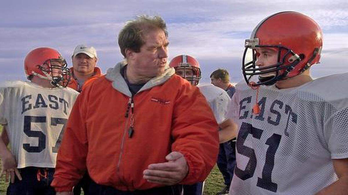 Olathe East football coach Jeff Meyers (center) talked to his players during practice in 2002. Meyers was fired Monday after his his first losing season since 1999.


